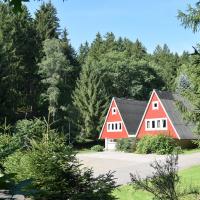 Fotografie einer roten Rennsteigwanderhütte mit doppeltem Spitzdach im Wald.